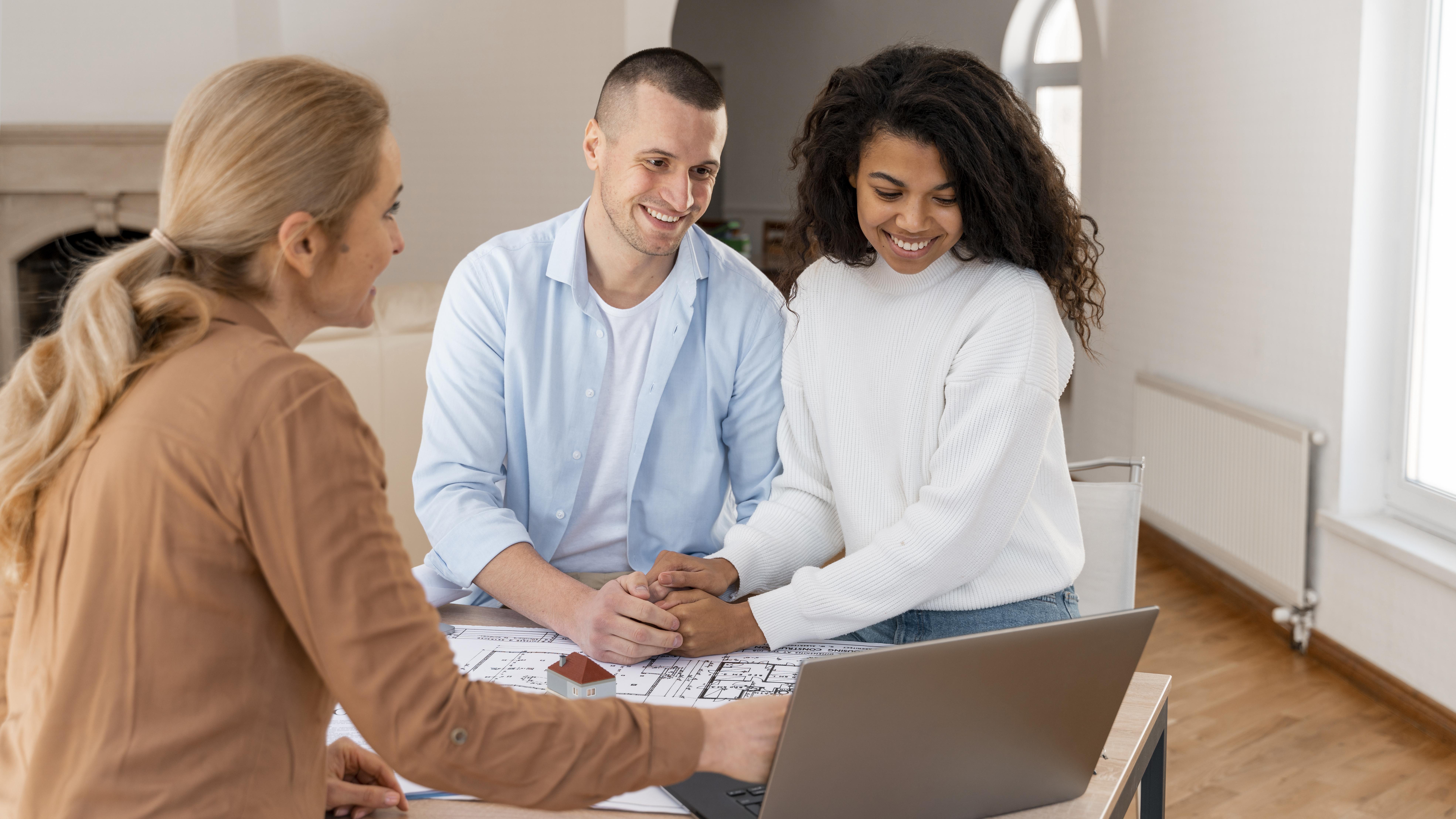 smiley realtor showing new house couple laptop